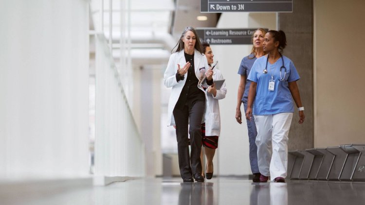 Medical professionals walking down a hospital hallway while engaging in conversation