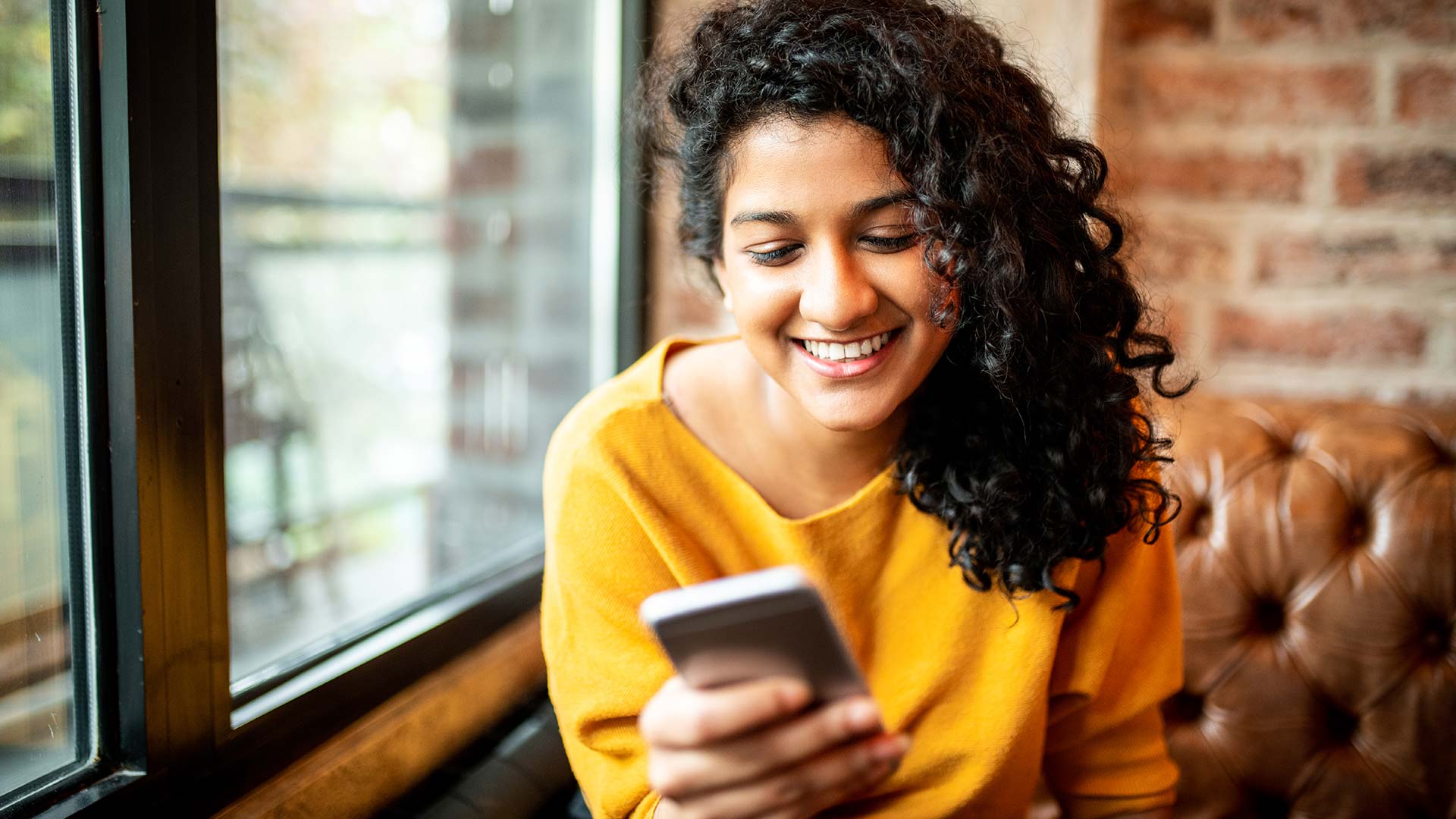 Young woman views her employee benefits on her mobile phone